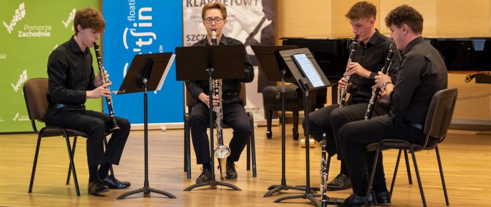 Kwartet klarnetowy gra na instrumentach utwór umieszczony na pulpitach, w sali koncertowej ZPSM w Szczecinie