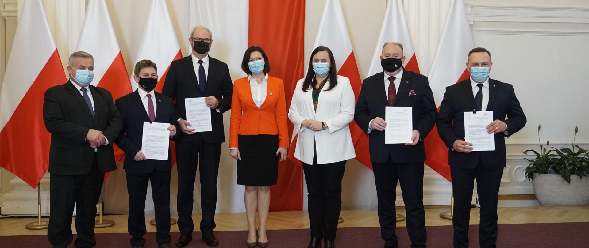 uczestnicy uroczystości prezentują podpisane umowy grantowe