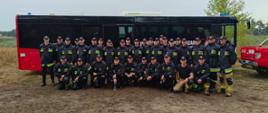 Zdjęcie grupowe kadetów Centralnej Szkoły PSP (30 osób) w towarzystwie dwóch dowódców oraz kierowcy na tle autokaru PSP