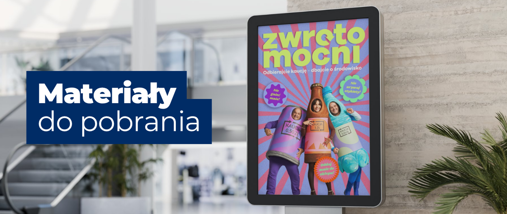 na zdjęciu widoczny jest napis: Materiały do pobrania. Po prawej stronie zdjęcia na ekranie reklamowym wyświetla się plakat z napisem: Zwrotomocni. Odbierajcie kaucję - dbajcie o środowisko. 