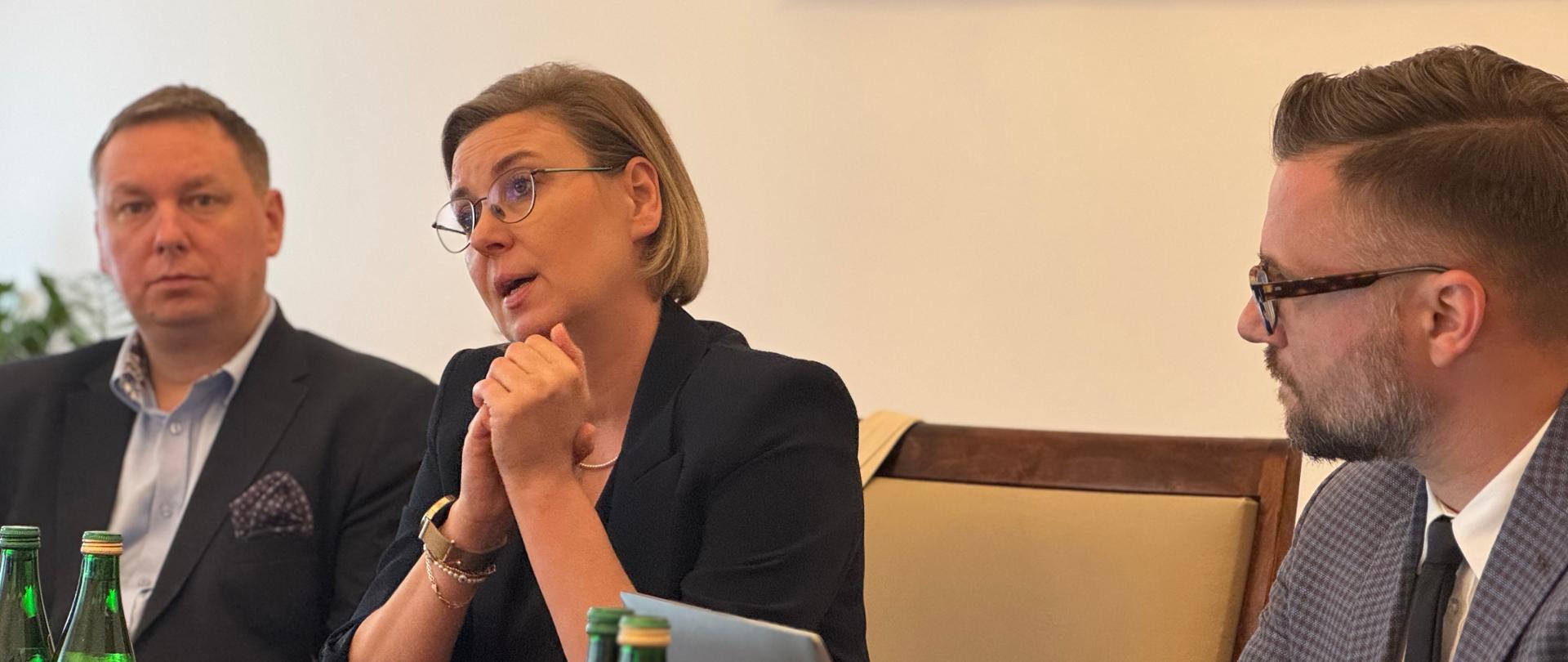 Zdjęcie wykonane podczas spotkania dotyczącego organizacji regionalnych podsumowań programu Moc Małych Społeczności, 3 września 2025 roku w Kancelarii Prezesa Rady Ministrów. Na zdjęciu widzimy Sekretarz Stanu Adrianę Porowską, Podsekretarza Stanu Marka Krawczyka oraz doradcę Sekretarza Stanu w KPRM – Piotra Steca.