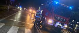 Na zdjęciu widoczny jest samochód ratowniczo gaśniczy z włączonymi sygnałami świetlnymi podczas prowadzonych działań.
