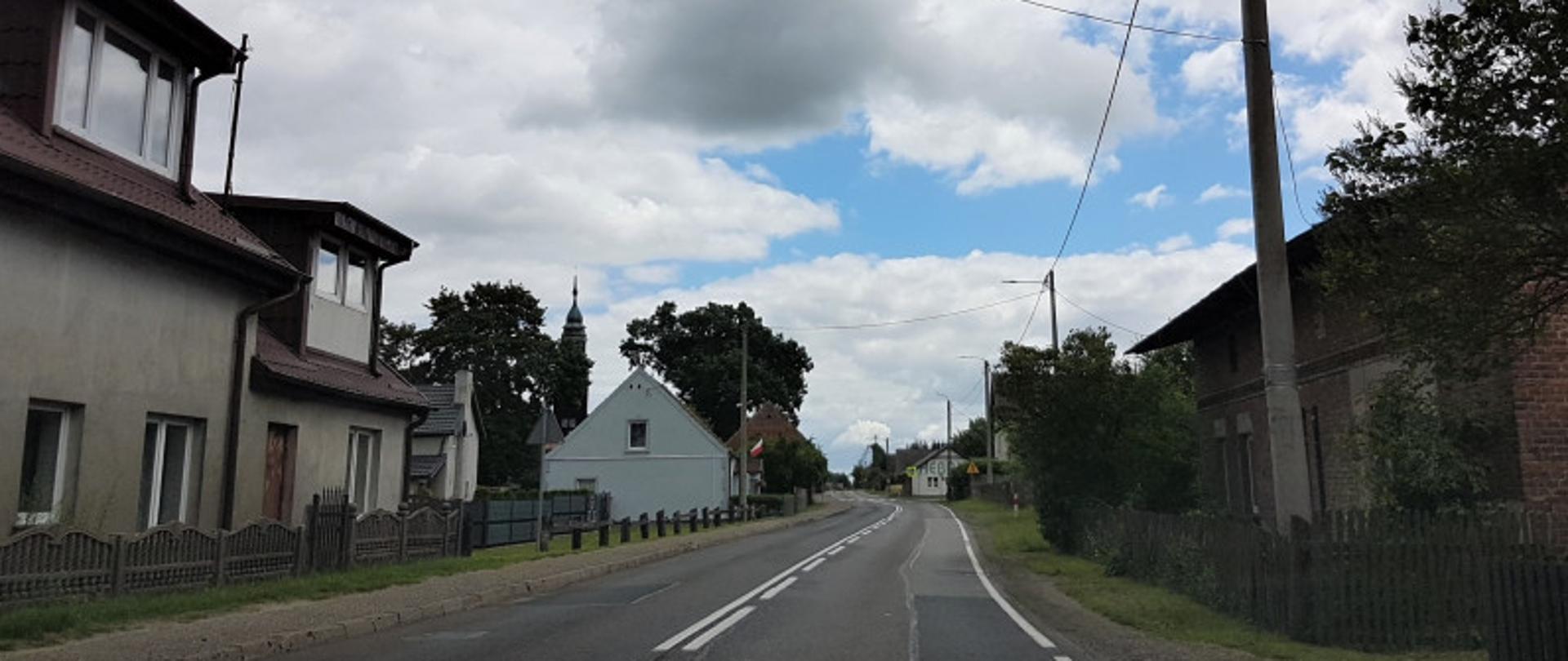 Na zdjęciu widoczna droga krajowa nr 25 przebiegająca przez miejscowość Brzezie. Widoczne niskie zabudowania mieszkalne przy samej drodze.