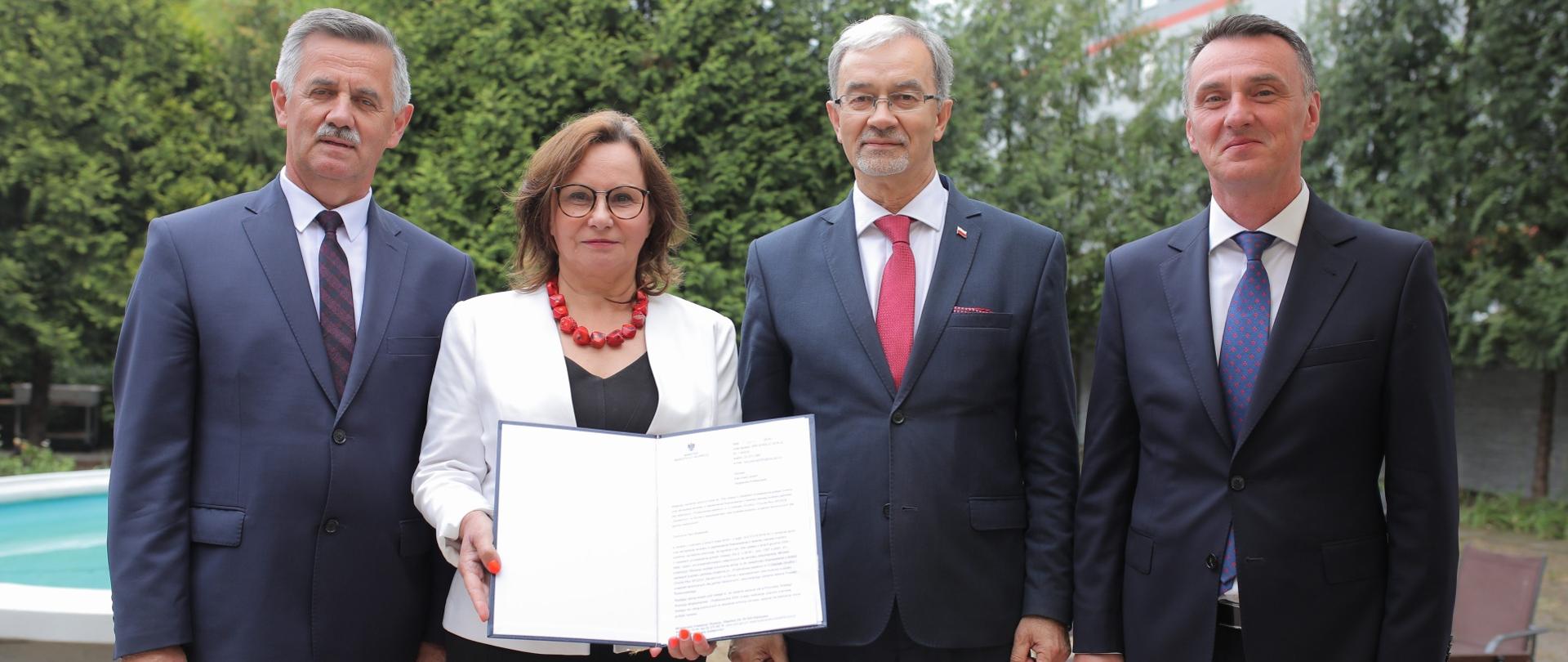 uczestnicy spotkania prezentują dokument potwierdzający dofinansowanie