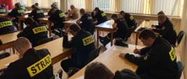 zdjęcie przedstawia strażaków w Sali szkoleniowej podczas egzaminu teoretycznego