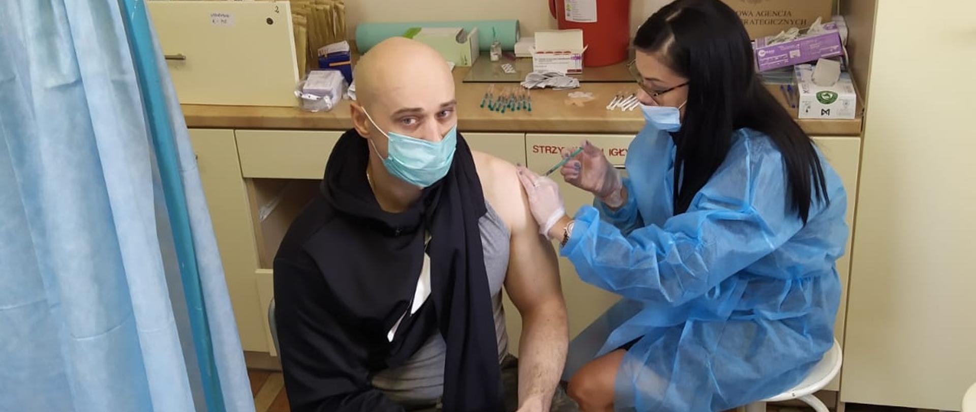 Funkcjonariusz JRG Sulęcin podczas szczepienia