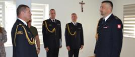 Dowódca uroczystości składa meldunek Komendantowi Powiatowemu PSP, strażacy w pomieszczeniu , w umundurowaniu galowym