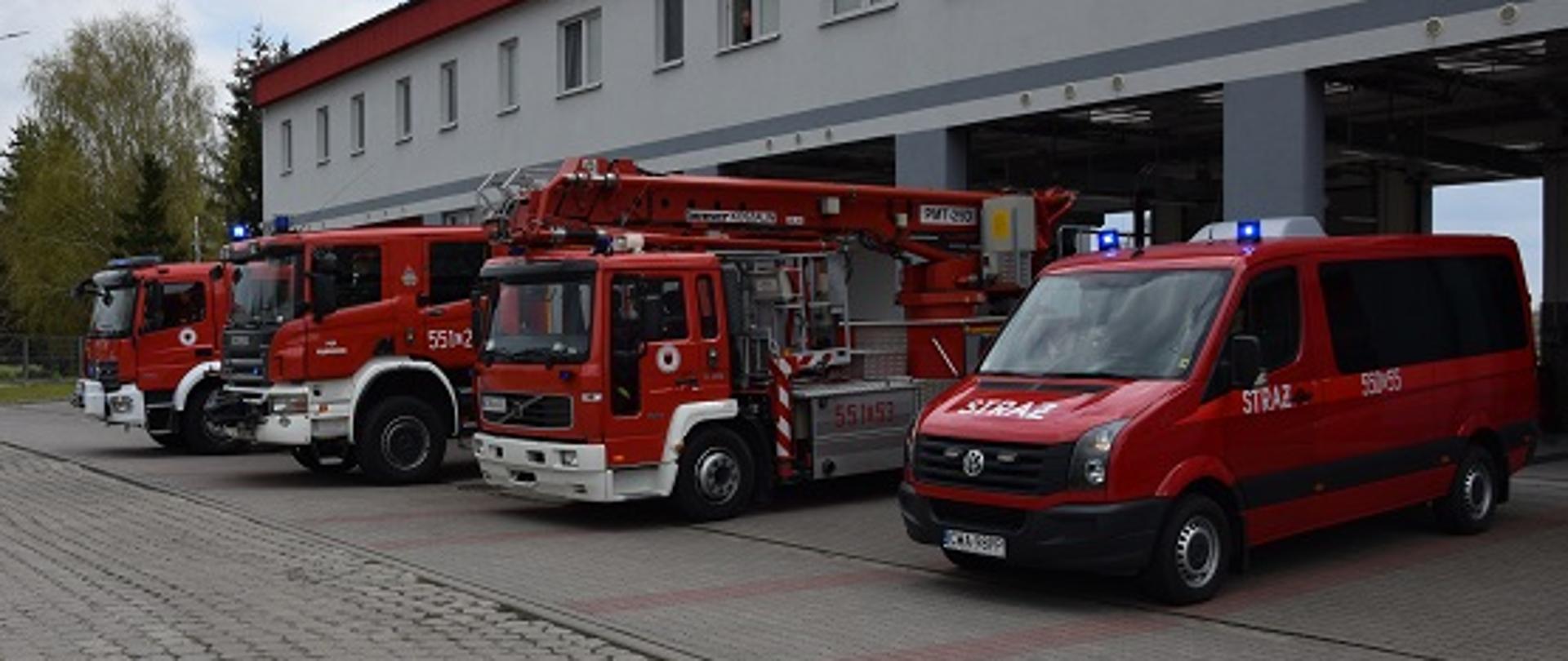 Samochody pożarnicze z włączonymi światłami błyskowymi przed budynkiem KP PSP w Wąbrzeźnie