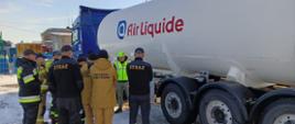 Zdjęcie przedstawia strażaków uczestniczących w warsztatach oraz pracownika firmy AirLiquide Polska Sp. z o.o. w trakcie praktycznego omówienia budowy cysterny do przewozu cieczy kriogenicznych.