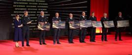 Zdjęcie przedstawia nadbryg. Krzysztofa Hejduk zastępcę komendanta głównego PSP oraz laureatów programu „ORLEN dla Strażaków” trzymającymi promesy.