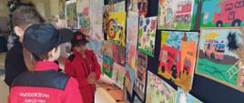 Widok z boku - uczestnicy OTWP oglądają prace z konkursu plastycznego.