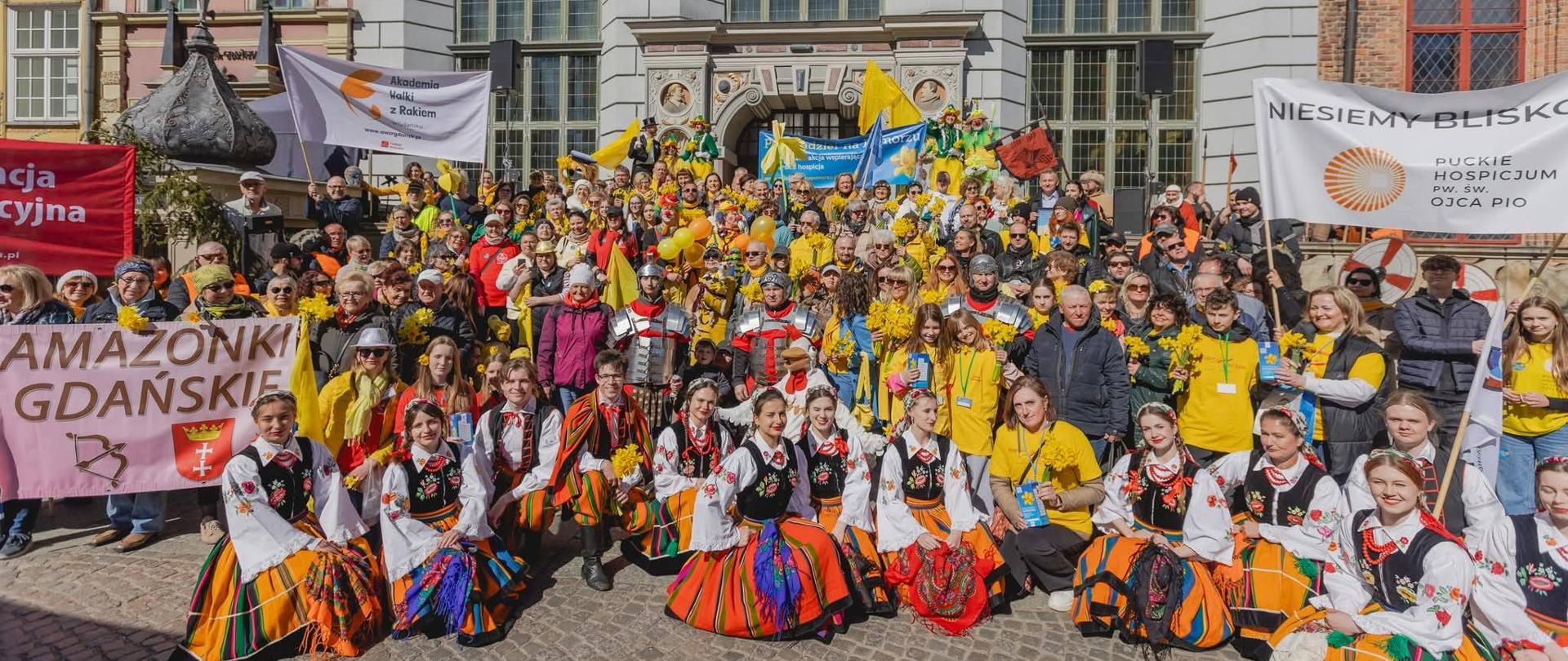 grupa osób ubranych w żółte i ludowe stroje pozuje do zdjęcia obok gdańskiego Neptuna, to finał akcji Pola nadziei, Gdańsk, 26.04.2026