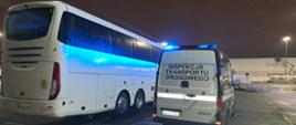 Inspektorzy małopolskiej Inspekcji Transportu Drogowego kontrolują autokar przed wyjazdem z grupą młodzieży.