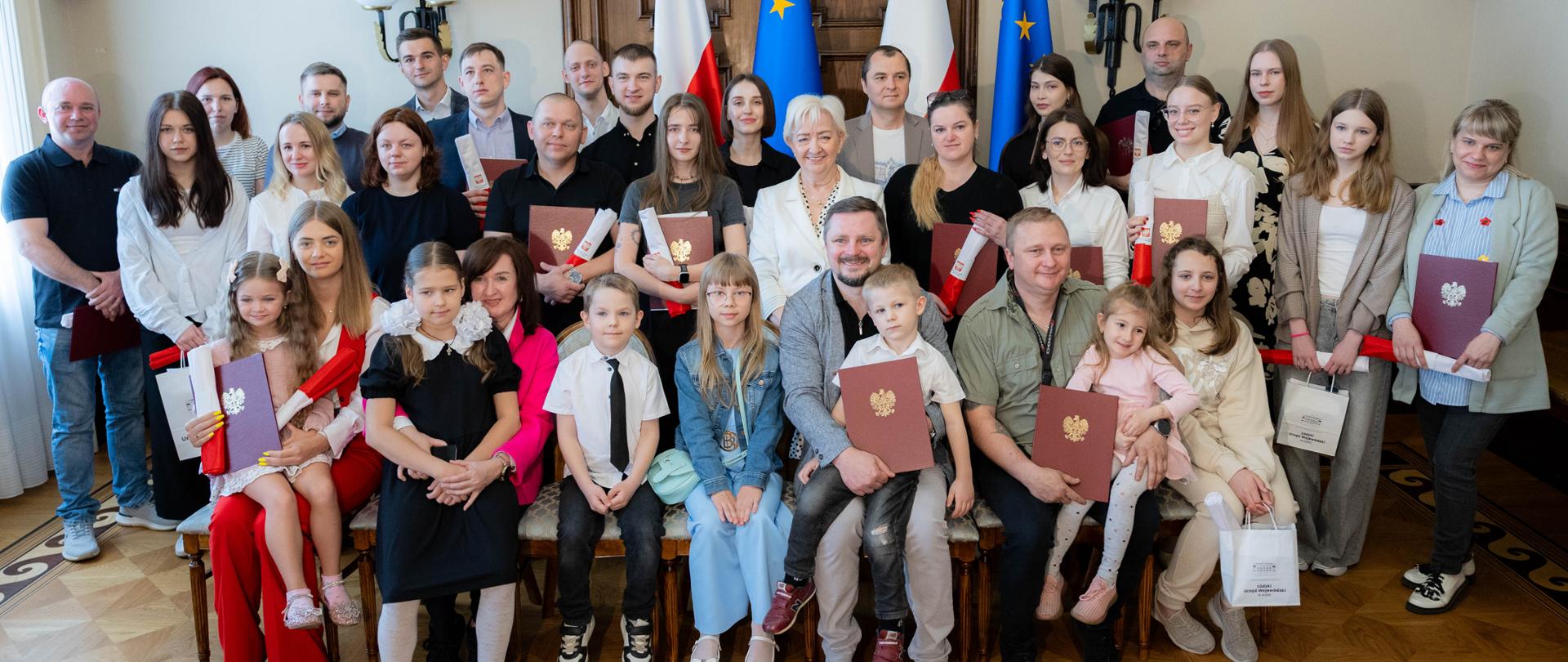 Wspólna fotografia wojewody łódzkiego Doroty Ryl z nowymi obywatelami 