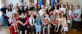 Wspólna fotografia wojewody łódzkiego Doroty Ryl z nowymi obywatelami 