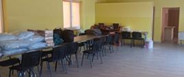 Świetlica w jednostce OSP i zmagazynowane na stołach koce, pościele, śpiwory w celu wykonania miejsc noclegowych