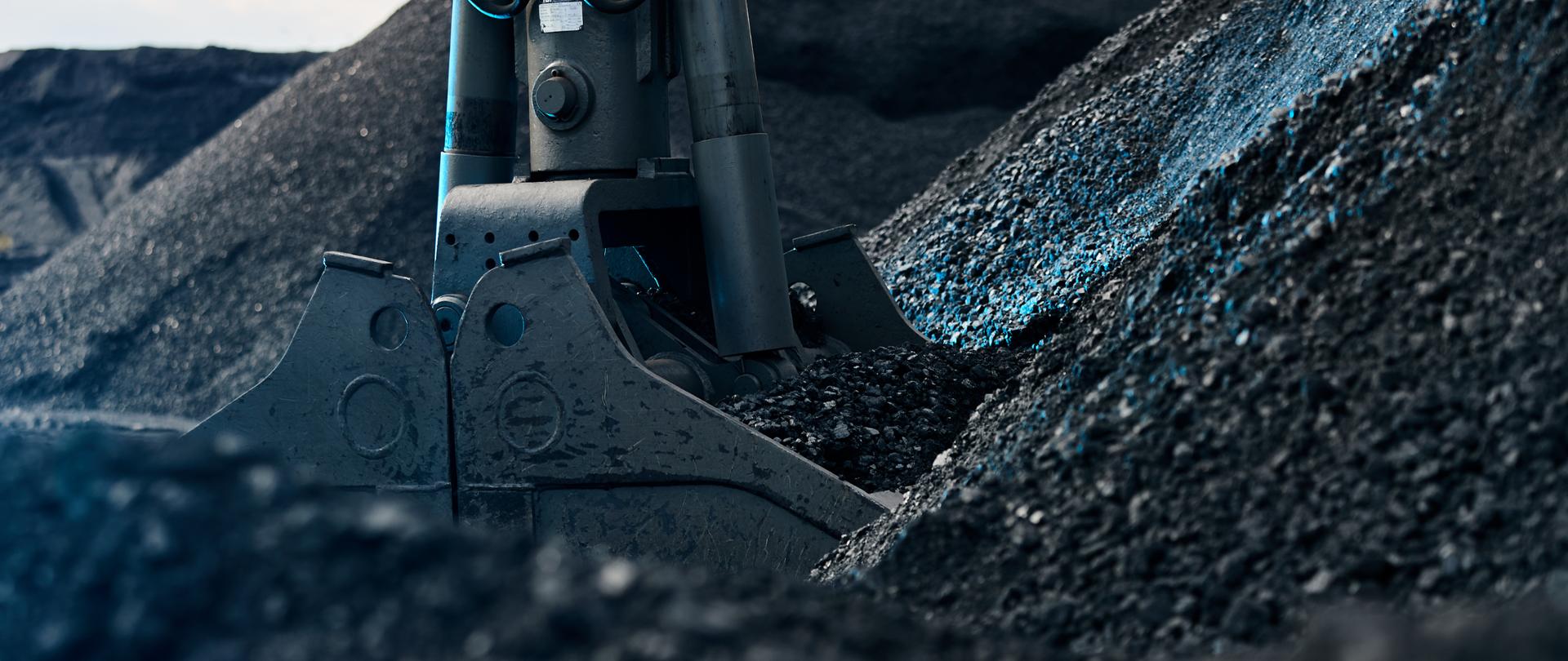 Coal loading excavator, heaps of coal