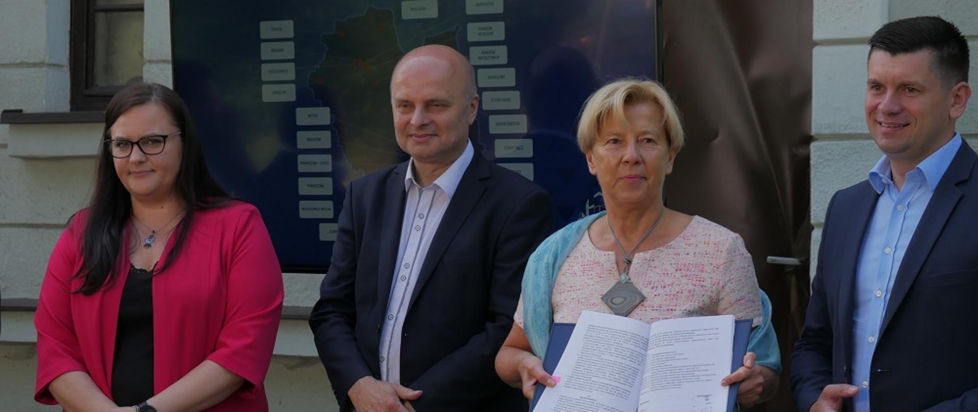 Na zdjęciu są cztery osoby: dwie kobiety i dwóch mężczyzn, w tym minister Małgorzata Jarosińska-Jedynak (pierwsza z lewej). Małgorzata Zielińska, członek zarządu PKP trzyma podpisaną umowę