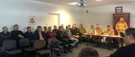 Na zdjęciu widoczny jest Komendant Powiatowy Państwowej Straży Pożarnej w Ostrowcu Św., Zastępca Komendanta Powiatowego Państwowej Straży Pożarnej w Ostrowcu Św., funkcjonariusze PSP, przedstawiciele gmin oraz druhowie OSP w trakcie spotkania nt. strategii rozwoju ochrony przeciwpożarowej.