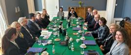 Wiceminister Mościcka-Dendys z członkami Komitetu Prawnego i ambasador RP w Królestwie Niderlandów siedzą przy stole na obradach w Hadze

