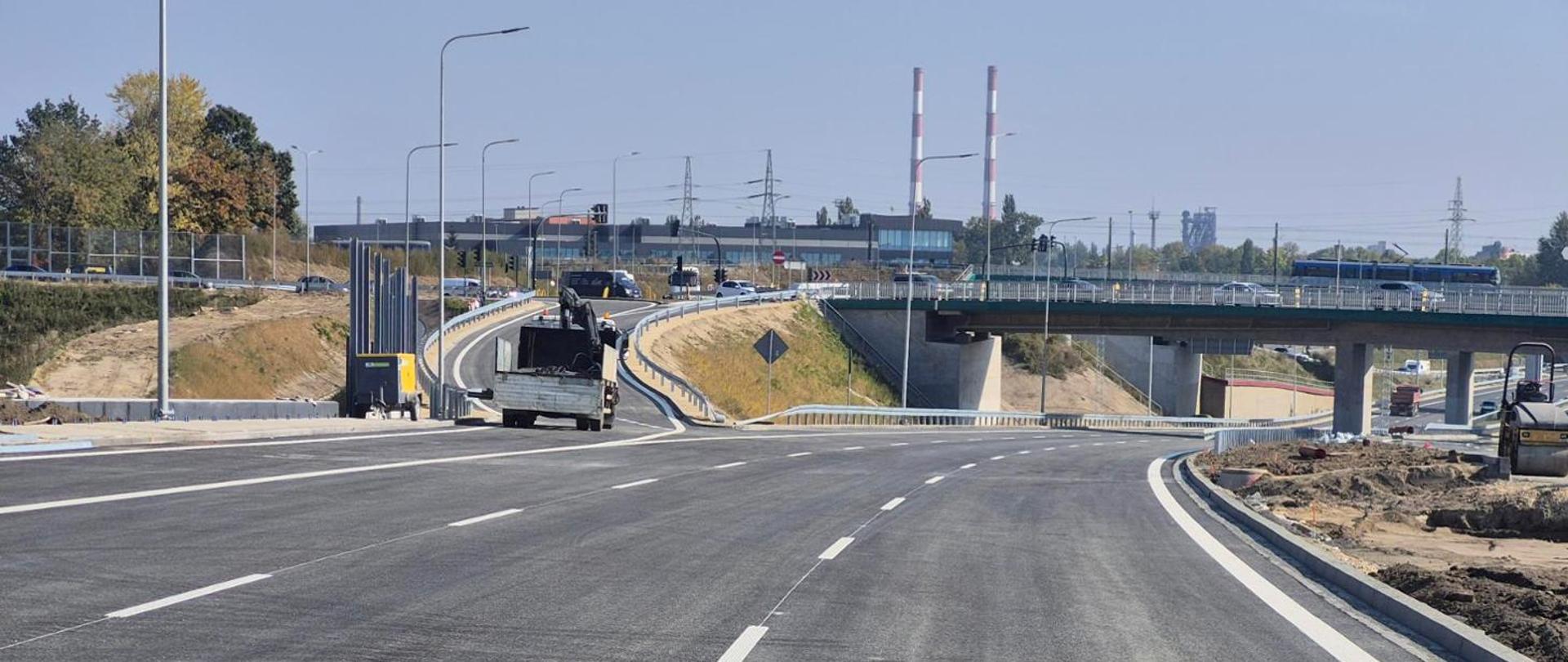 zamknięta i pomalowana jezdnia S7, w tle wiadukty węzła Grębałów, w oddali kominy Kombinatu