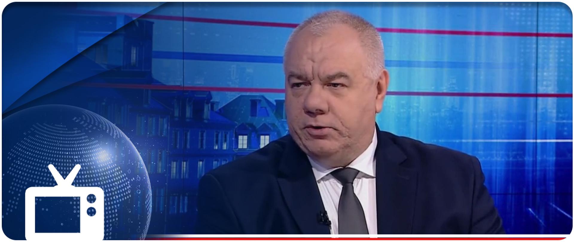 Wicepremier Jacek Sasin w "Gość Wiadomości". W lewym dolnym rogu ikonka telewizora. 