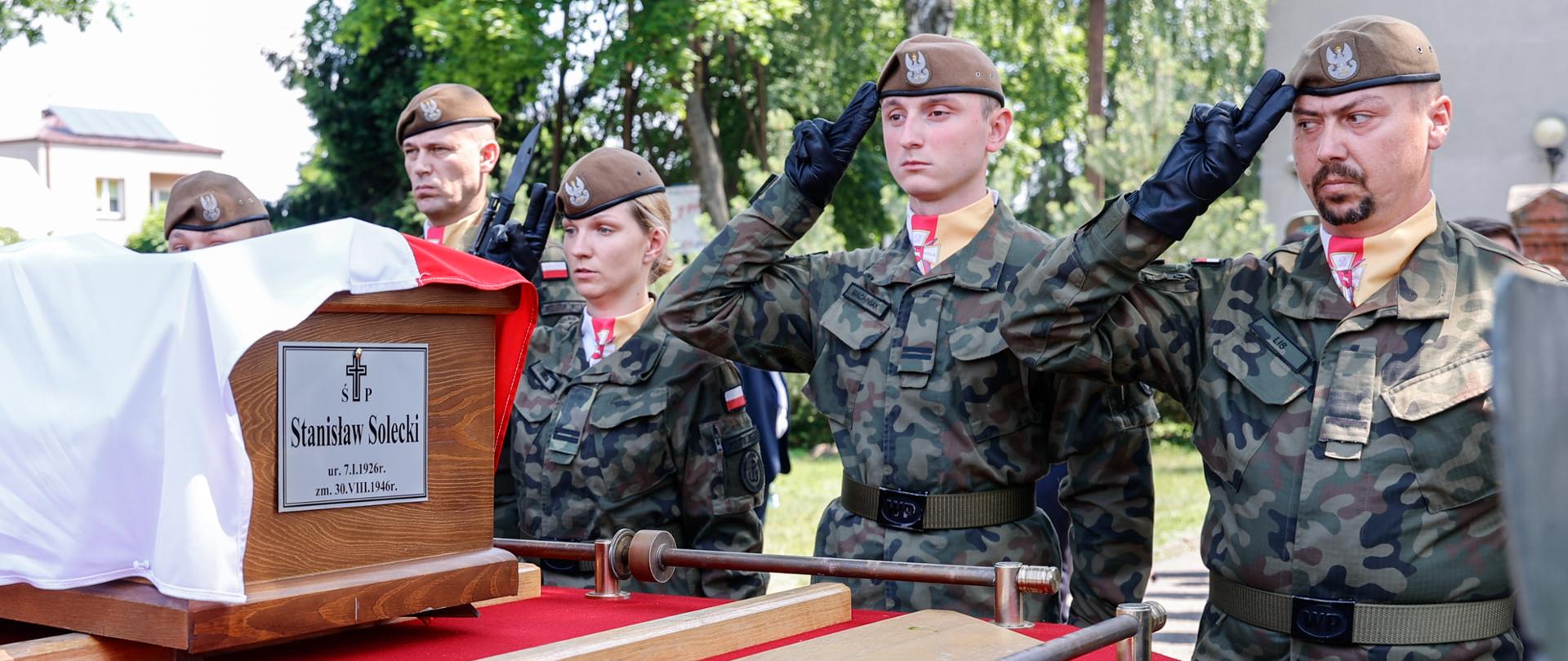 Żołnierze salutują nad trumną.