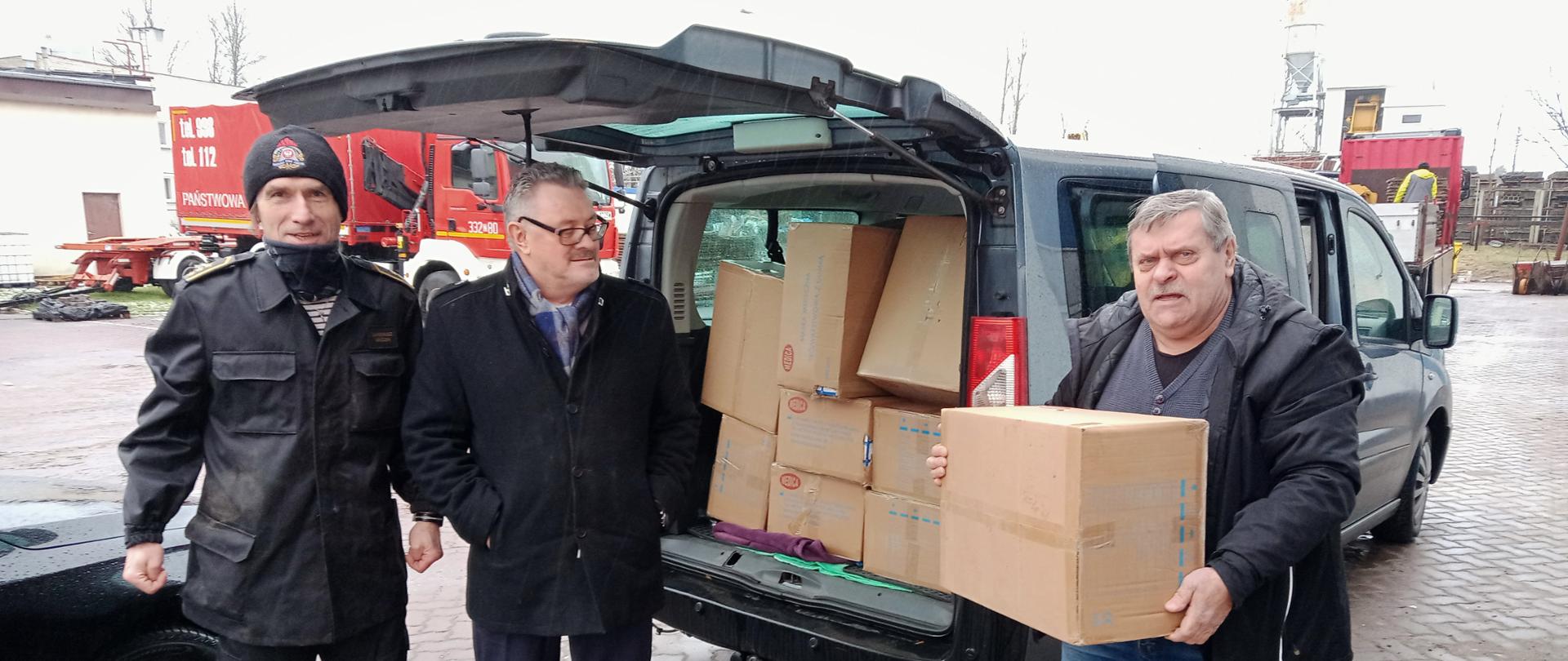 Strażacy przekazują środki ochrony indywidualnej. Na zdjęciu przedstawicielom gminy Sianów.