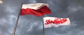 pomnik, dwa krzyże, z dwóch stron stoją maszty z powiewajacymi flagami, jedna to flaga biało-czerwona, druga biała z napisem solidarność
