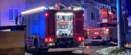 Na zdjęciu widzimy dwa zastępy PSP. Ratownicy przy użyciu drabiny mechanicznej ewakuują uwięzionego na balkonie mieszkańca.