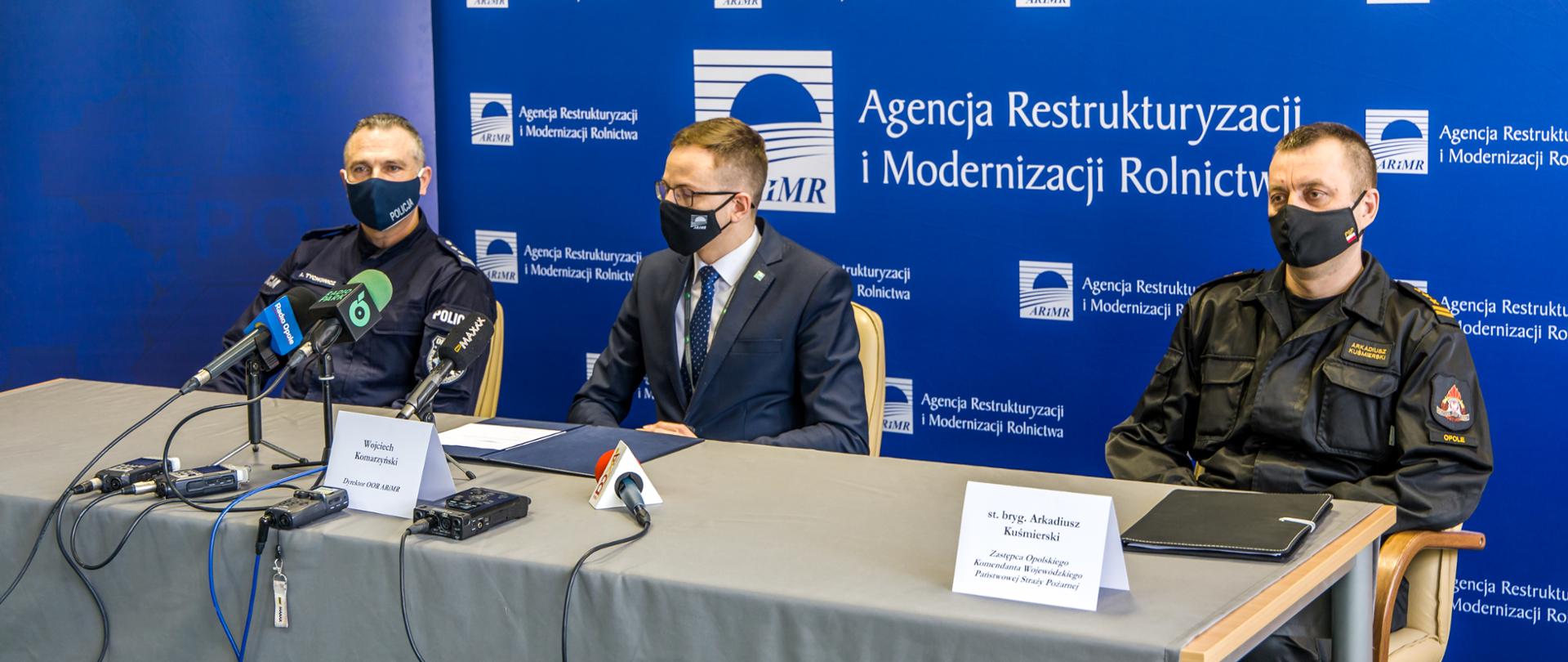 Na zdjęciu widoczny Zastępca Komendanta Wojewódzkiego PSP w Opolu st. bryg. Arkadiusz Kuśmierski, Dyrektor OOR ARIMR Wojciech Komarzyński oraz I Zastępca Komendanta Wojewódzkiego Policji w Opolu insp. Adam Tychowicz. Panowie brali udział w konferencji prasowej związanej z problemem wypalania traw w sezonie wiosennym.