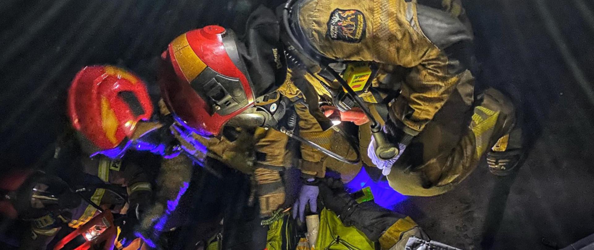 Strażacy podczas ćwiczeń ubrani w ubrania specjalne oraz aparaty powietrzne 