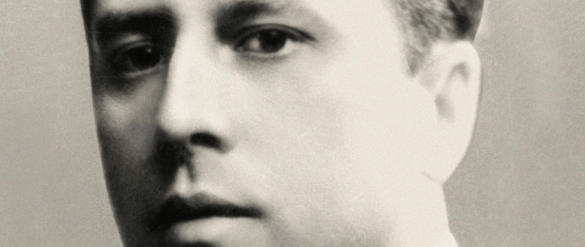 Tadeusz Romer - portret mężczyzny, półprofil, ciemne włosy, ciemna marynarka, ciemny krawat, biała koszula.