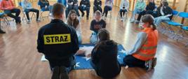 Funkcjonariusz tut. Komendy przedstawia podstawowe zasady udzielania pierwszej pomocy na fantomie szkoleniowym