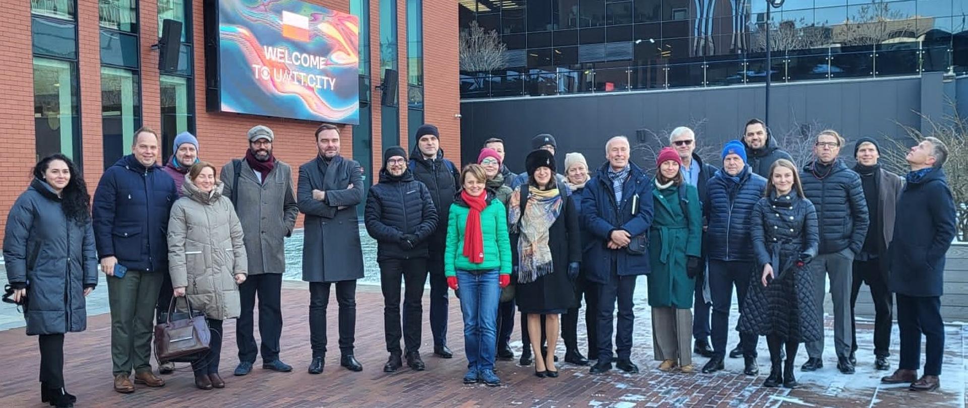 Grupa przedstawicieli sześciu pracowni architektonicznych w Kijowie pozują na tle budynku