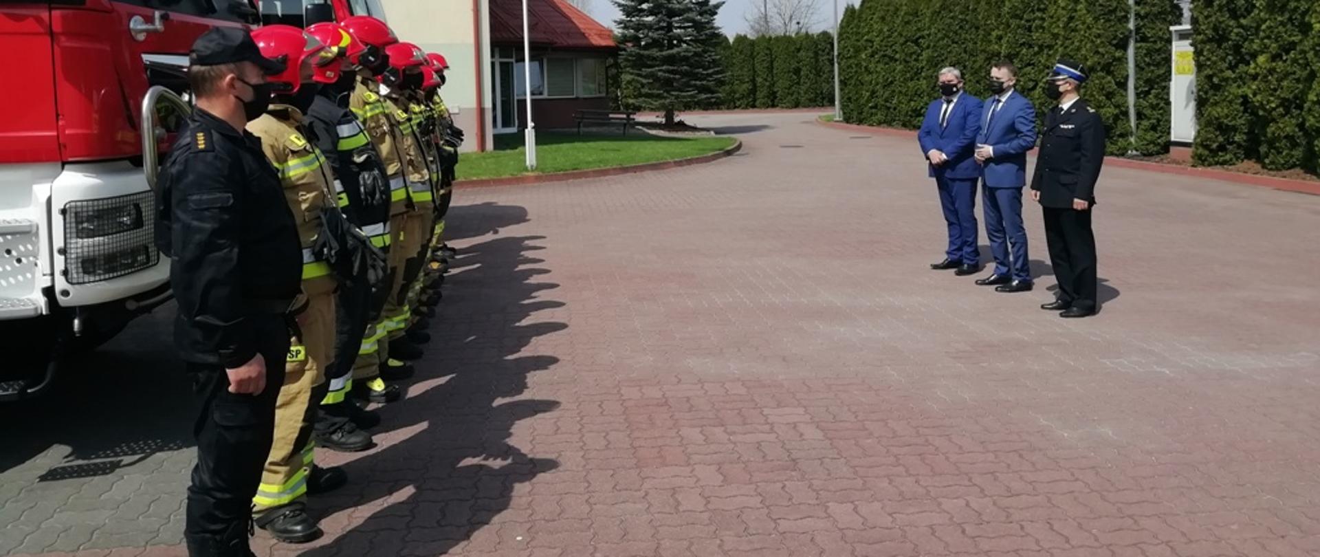 Na zdjęciu Pan Minister Michał Cieślak z Panem Maciejem Gawinem oraz komendantem powiatowym stoją przed strażakami z JRG Busko-Zdrój.