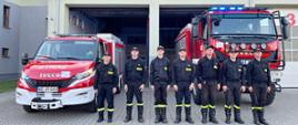 Minuta ciszy dla druha z Jednostki OSP Rumian - strażacy stoją w ubraniach koszarowych na placu przed budynkiem i samochodami