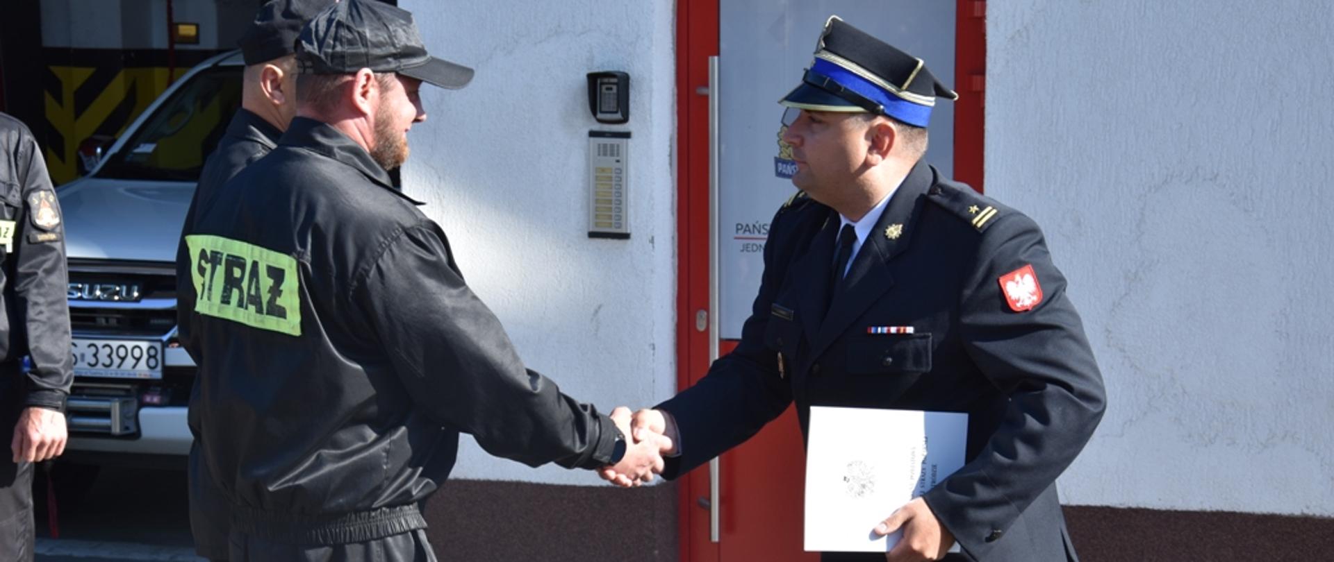 Kolejny strażak odbiera list pochwalny.