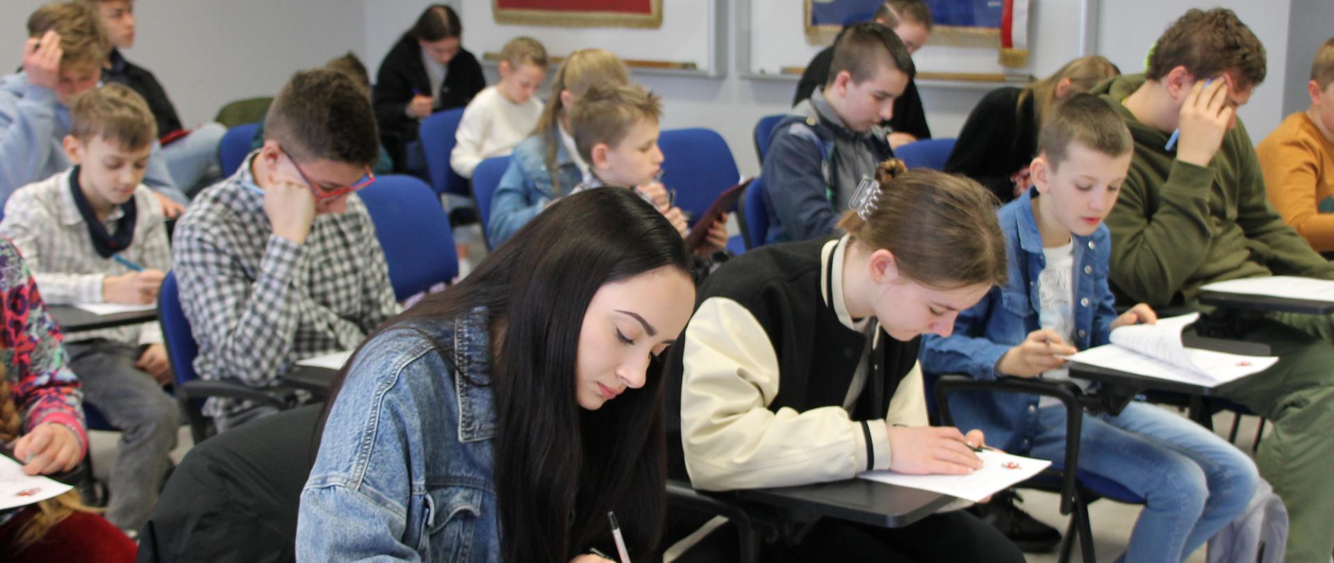 Na zdjęciu uczestnicy OTWP, którzy piszą test wiedzy.
