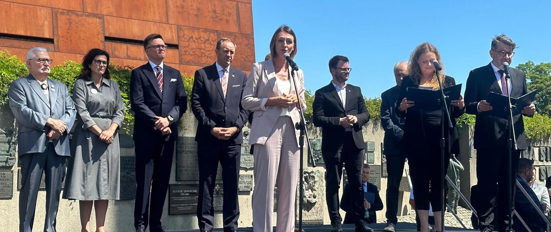 kobieta na dużym placu stoi i przemawia do publiczności