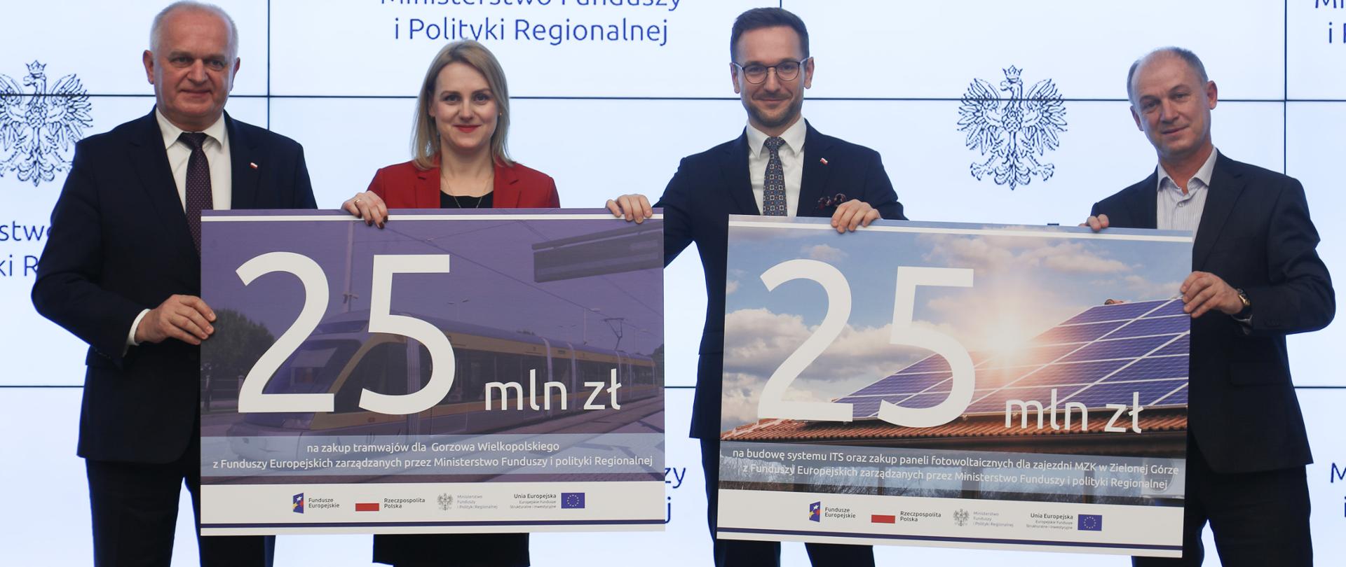 Cztery osoby trzymają dwie duże grafiki z napisami 25 mln zł. Drugi od prawej wiceminister Waldemar Buda.
