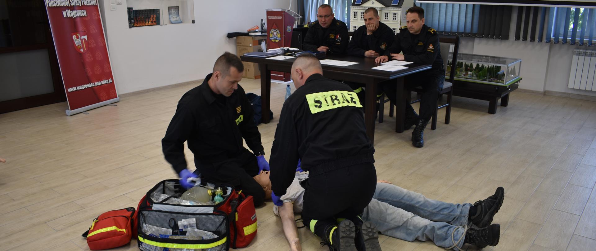 Na zdjęciu widać zdających egzamin strażaków oraz komisję egzaminacyjną 