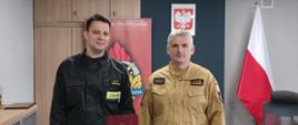 Komendant Powiatowy Państwowej Straży Pożarnej w Człuchowie st. bryg. Radosław Batruch stoi w gabinecie i wręcza akt mianowania na stanowisko zastępcy dowódcy Jednostki Ratowniczo - Gaśniczej w Człuchowie mł. kpt. Dawidowi Machnio. 