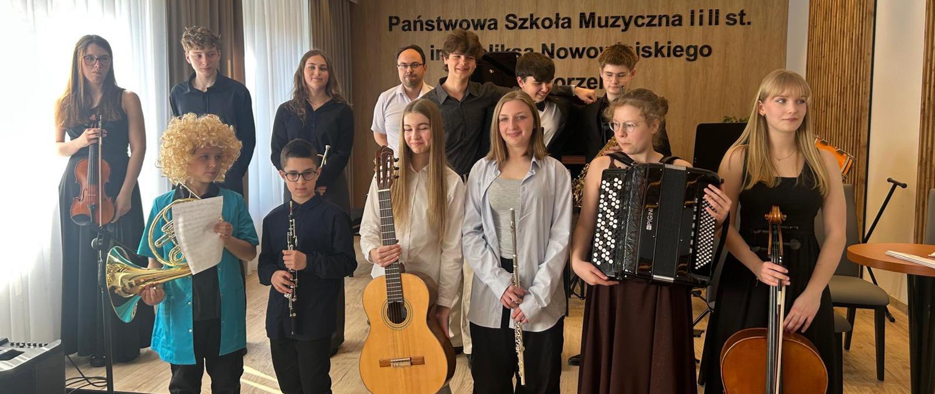 Zdjęcie grupowe wykonawców koncertu, uczniowie stoją z różnymi instrumentami.