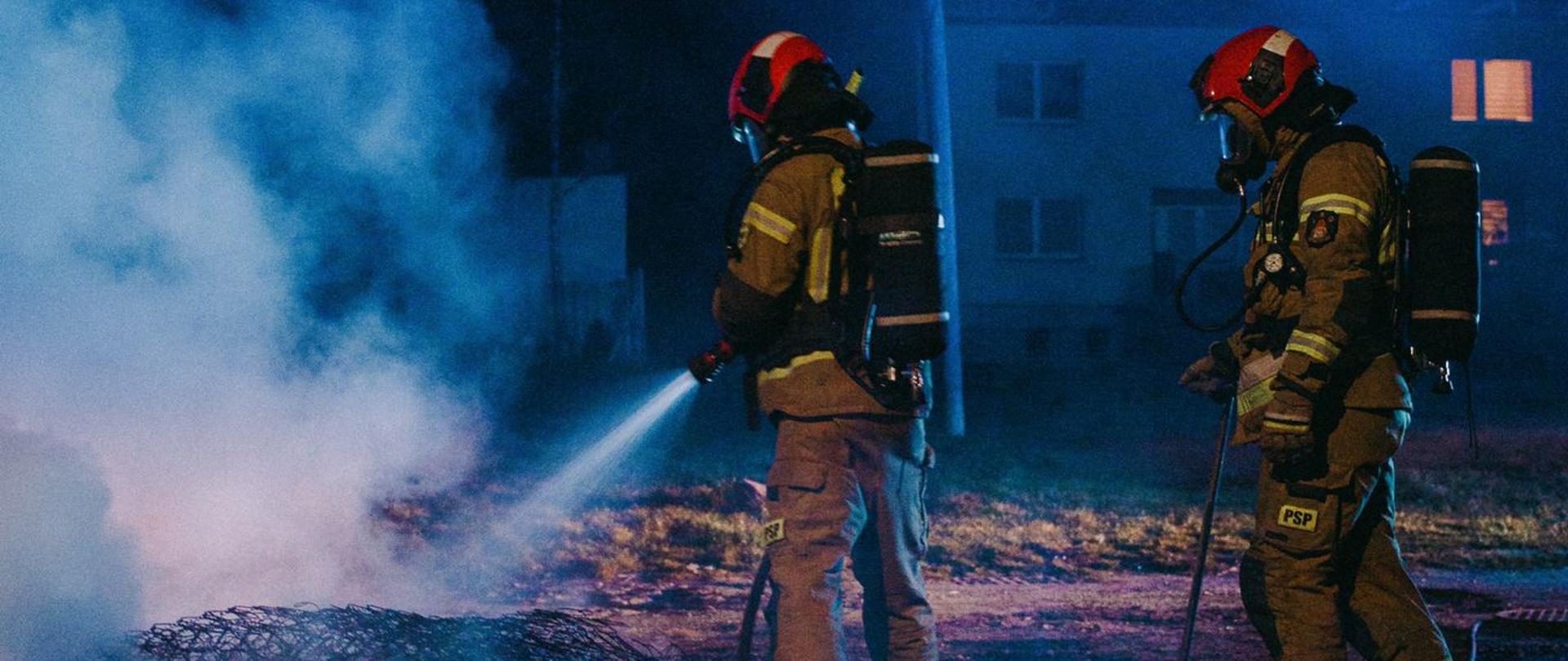 Podsumowanie zdarzeń w dniach 28.03 - 3.04.2022 r. - zdjęcie przedstawia strażaków ubranych w sprzęt ochrony układu oddechowego podczas dogaszania pożaru