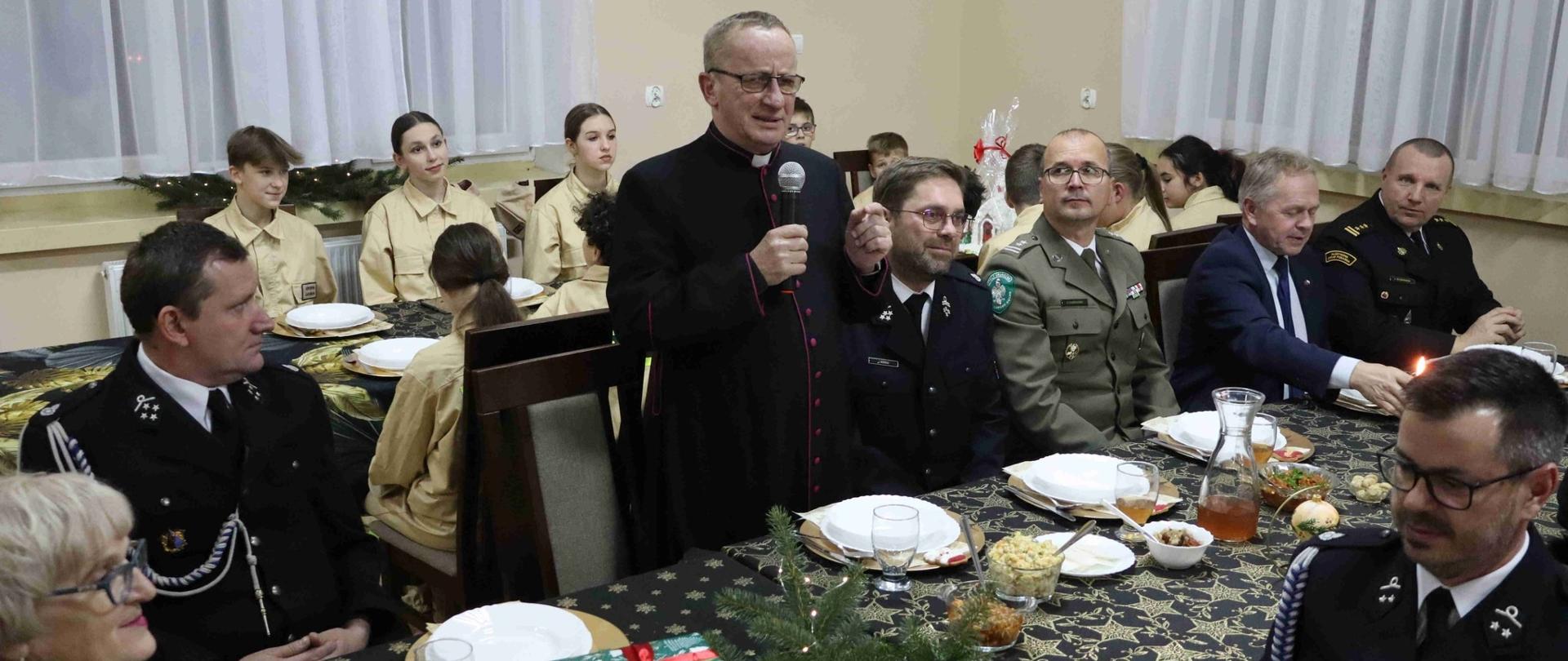 Trawa spotkanie opłatkowe strażaków ochotników gminy Braniewo, strażacy i zaproszeni goście siedzą za stołami.