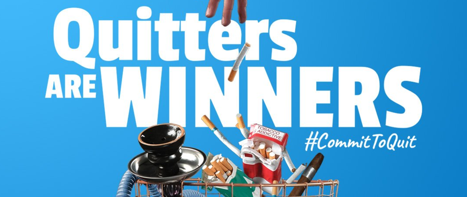 ręka wrzucająca do śmietnika: papierosy, e-papierosy, fajkę wodną, cygaro. Napis "Quitters are winners:. #Commit to Quit" 