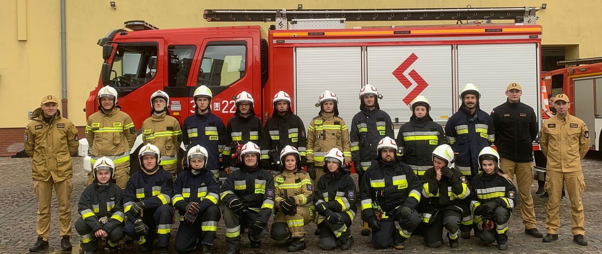 Widoczni strażacy z Ochotniczej Straży Pożarnej wraz z funkcjonariuszami Państwowej Straży Pożarnej.