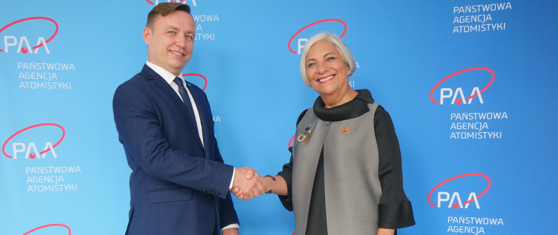 Prezes Państwowej Agencji Atomistyki (PAA) Andrzej Głowacki (z lewej) wymienia uścisk dłoni z Przewodniczącą Kanadyjskiej Komisji Dozoru Jądrowego (CNSC) Ruminą Velshi (z prawej)