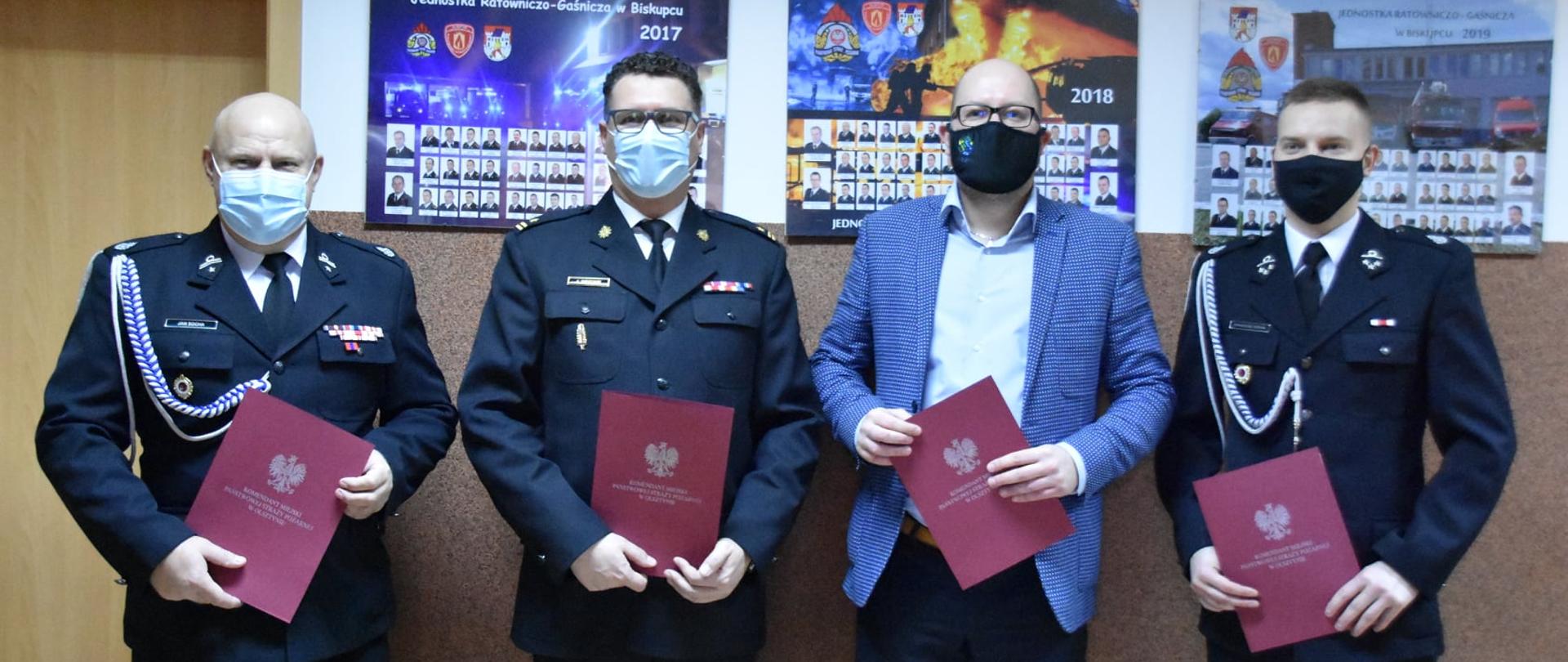 Zdjęcie przedstawia Komendanta Miejskiego Państwowej Straży Pożarnej w Olsztynie mł. bryg. Jarosława Gryciuka, wraz z Burmistrzem Miasta i Gminy Biskupiec Panem Kamilem Kozłowskim, dh Janem Sochą Prezesem OSP w Biskupcu oraz dh Arkadiuszem Sochą Naczelnikiem OSP w Biskupcu
